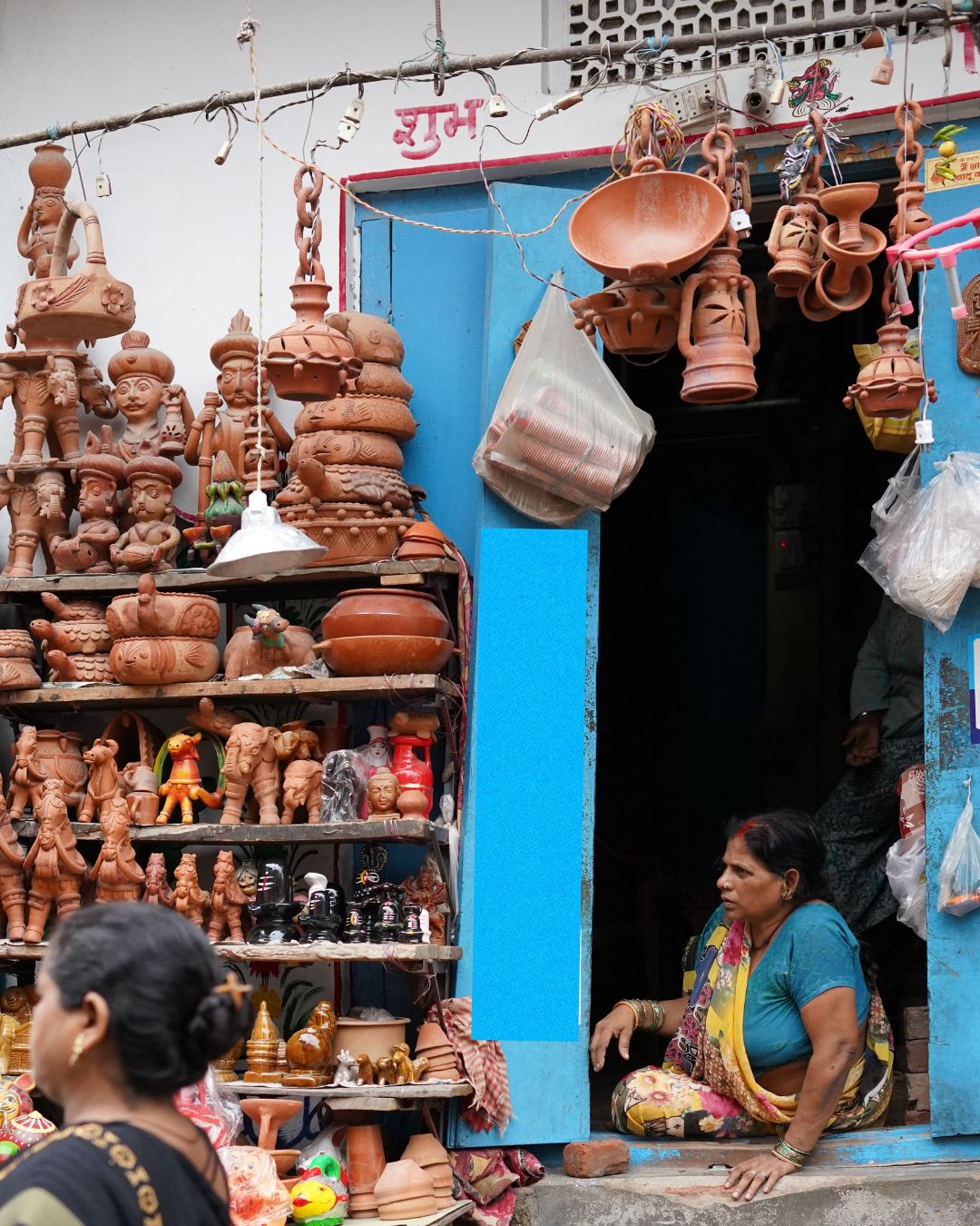 A shopkeeper at a local pottery and household goods stall in a Tier-2 Indian market